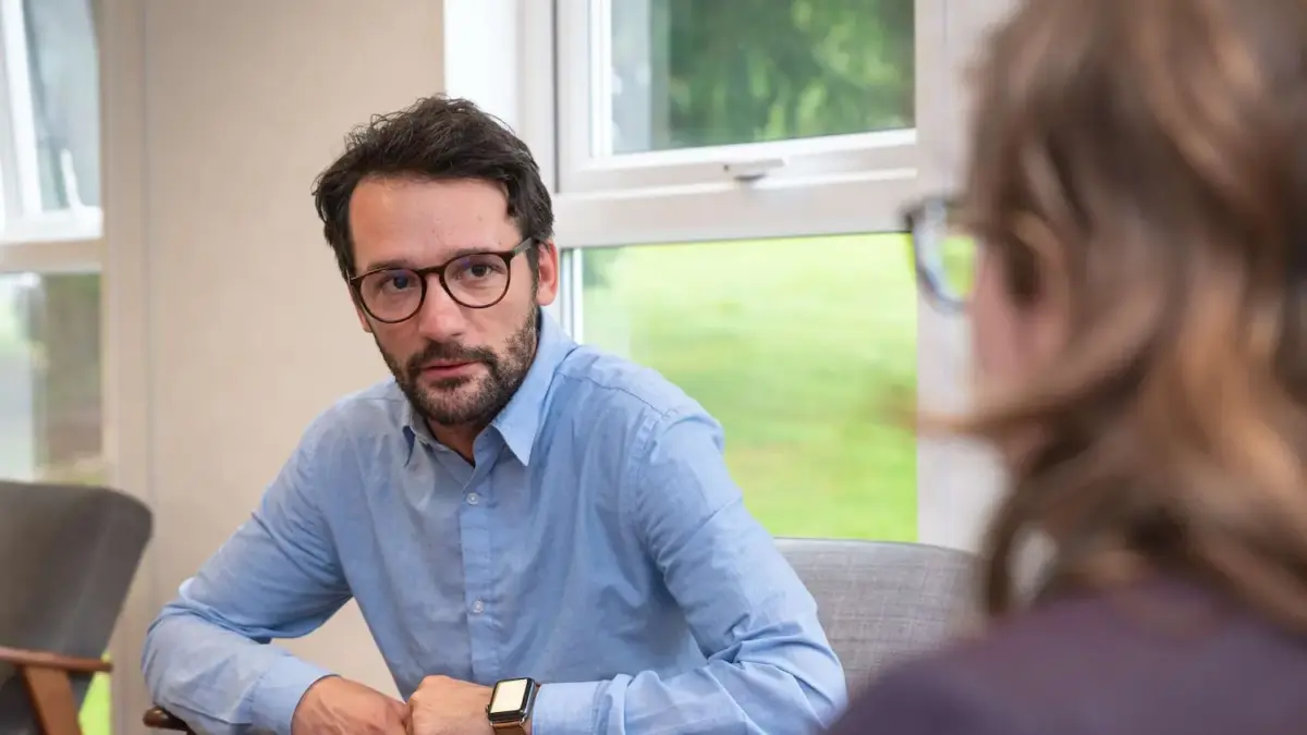 Over the shoulder image of a patient in recovery talking to an addiction therapist
