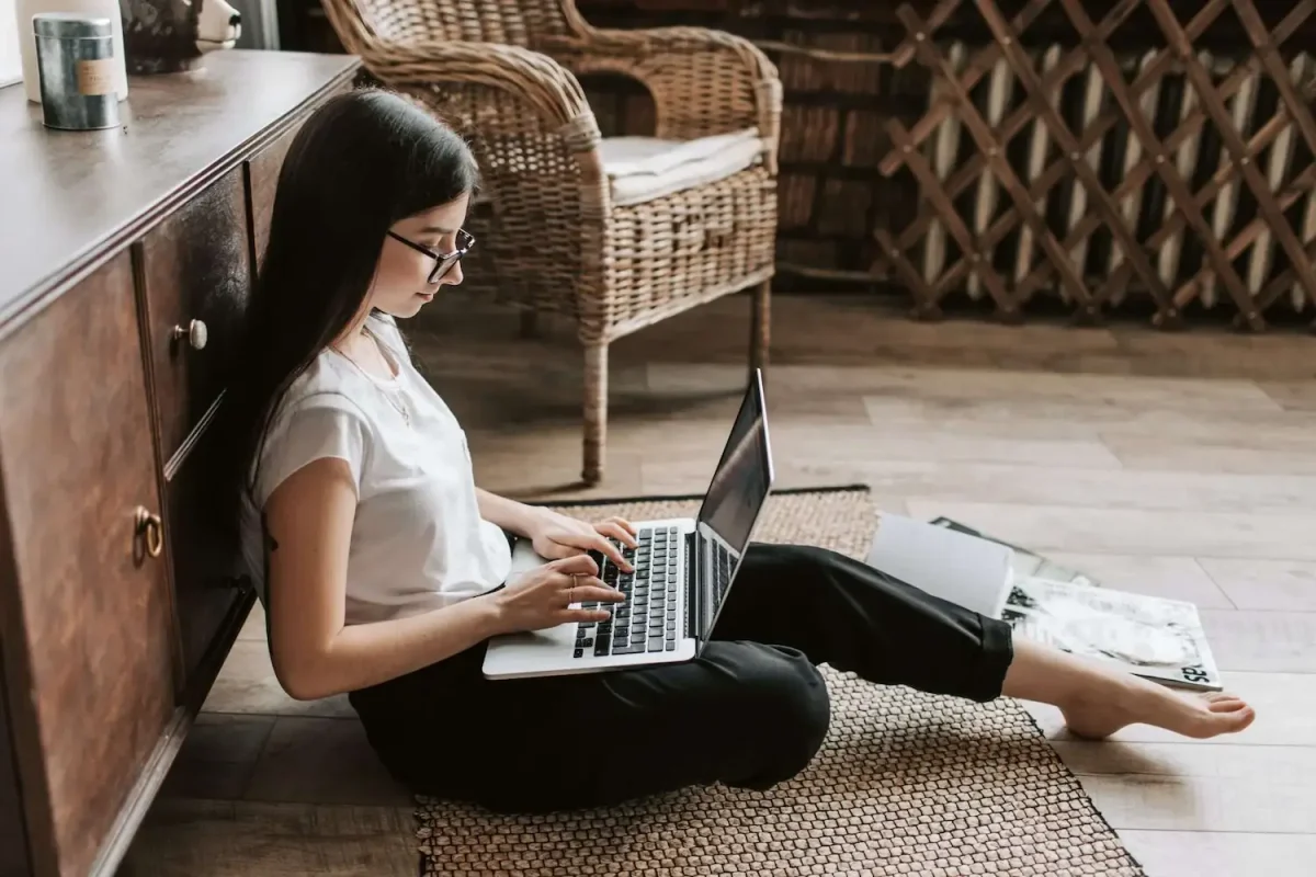 woman sitting on the floor working from home on a laptop