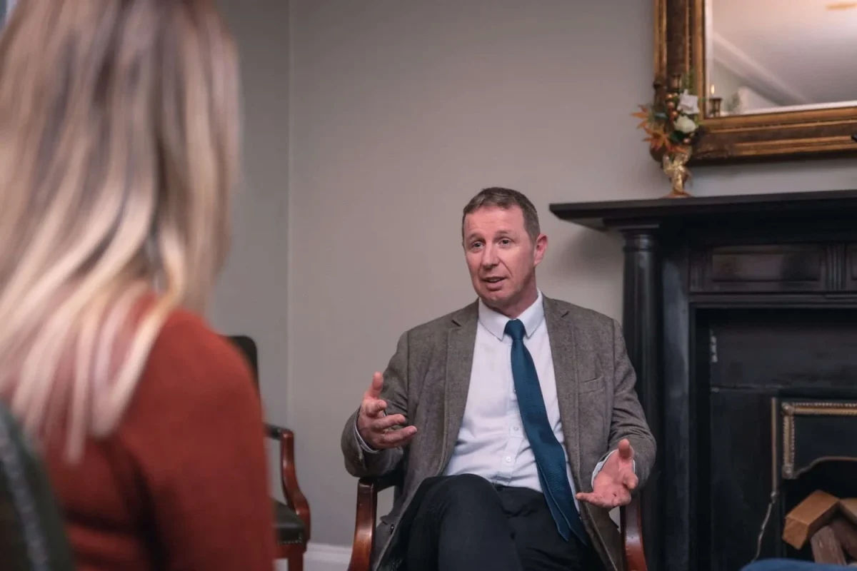 Indoor photo of a therapist explaining something to a patient during a session