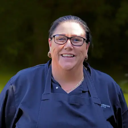 Portrait photo of Debbie Carolan, Chef at Smarmore Castle, photo taken outside against a stone wall background