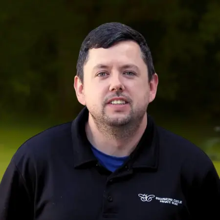 Portrait photo of Liam McQuillan, kitchen assistant at Smarmore Castle, photo taken outside against a stone wall background