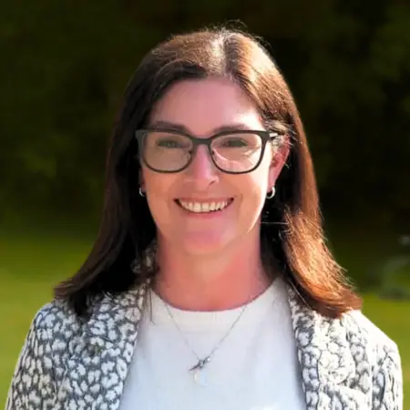 Portrait photo of Lorraine Byrne, addiction therapist at Smarmore Castle, photo taken outside with shrubs in the background