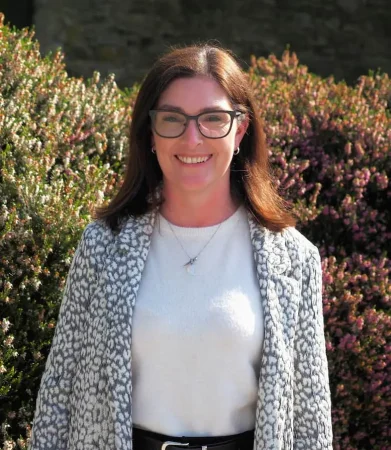 Portrait photo of Lorraine Byrne, addiction therapist at Smarmore Castle, photo taken outside with shrubs in the background