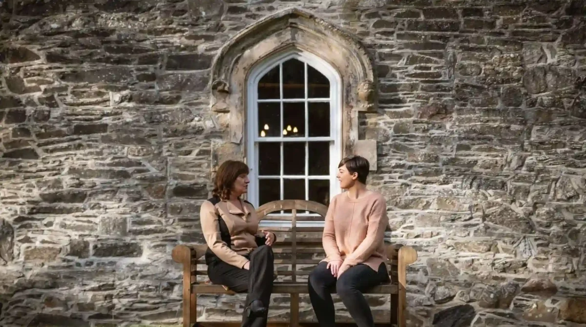 two women sitting and chatting outside of Smarmore Castle addiction clinic