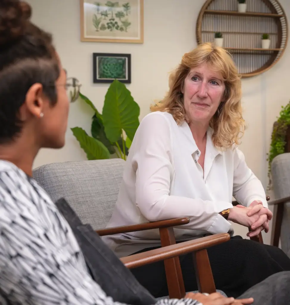 Two women talking sitting in chairs in addiction therapy session at Smarmore Castle rehab clinic in Ireland