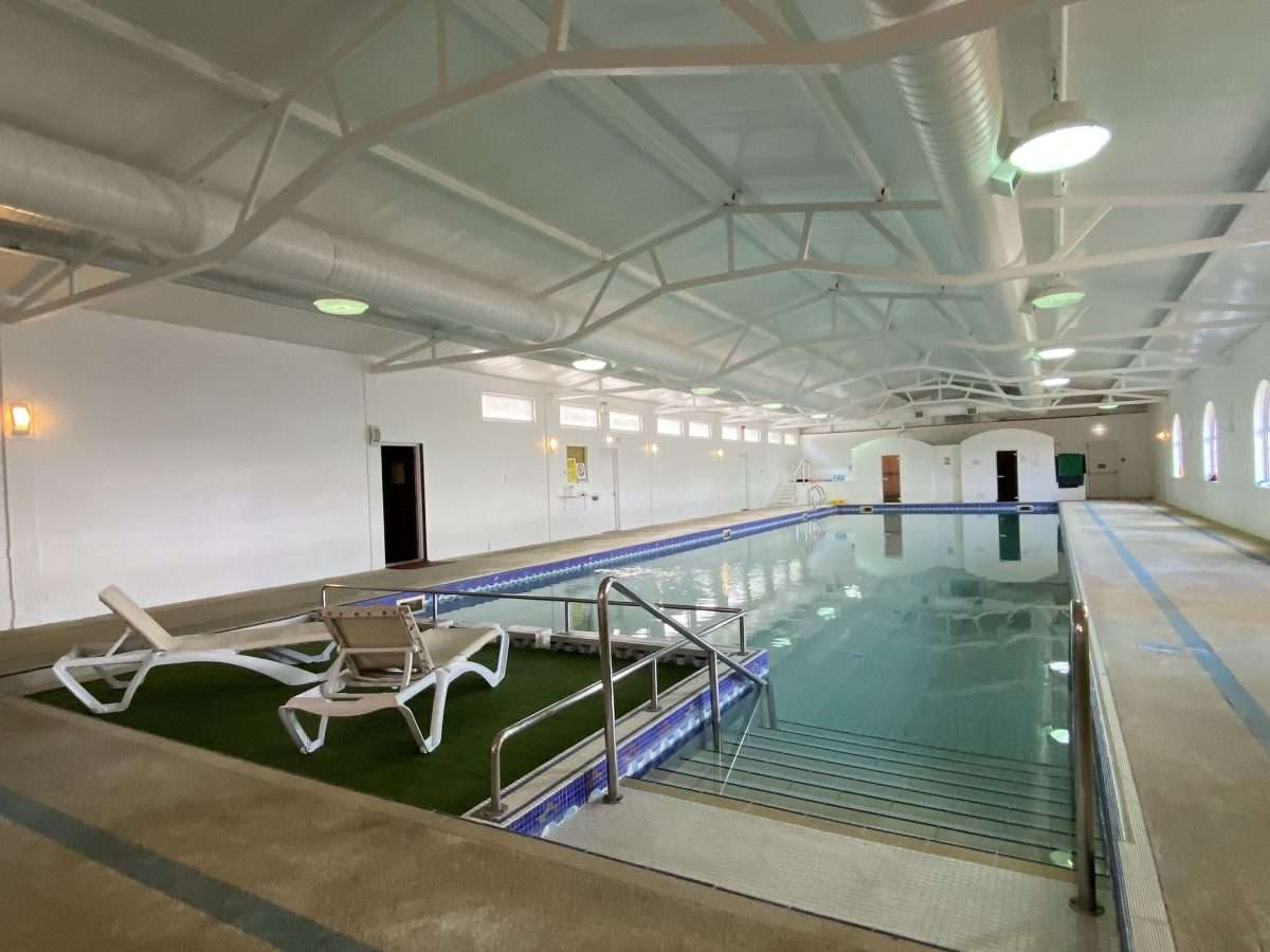Indoor swimming pool with two lounge chairs